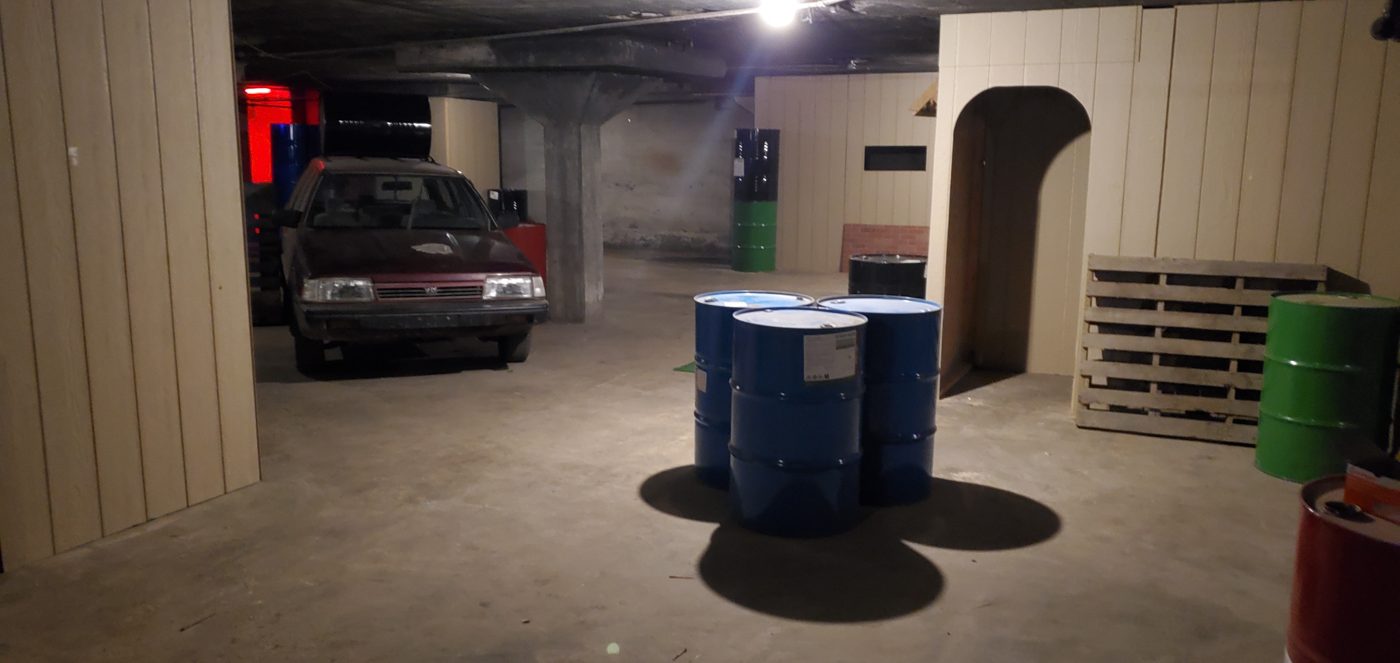 The arena floor with oil drums, pallets, walls and an old car