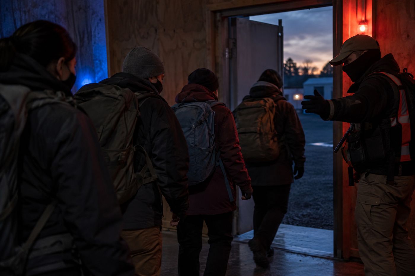 An instructor guiding a group out of a building during an evacuation drill